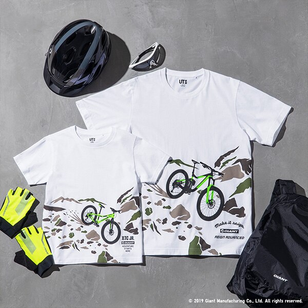 2 magliette bianche con la stampa di altrettante mountain bike su una montagna. In basso, il logo della Giant Bicycles.