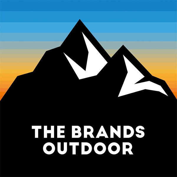 Una montagna nera, un tramonto come sfondo e, in bianco, il logo The Brands Outdoor che si staglia sulla montagna stessa.