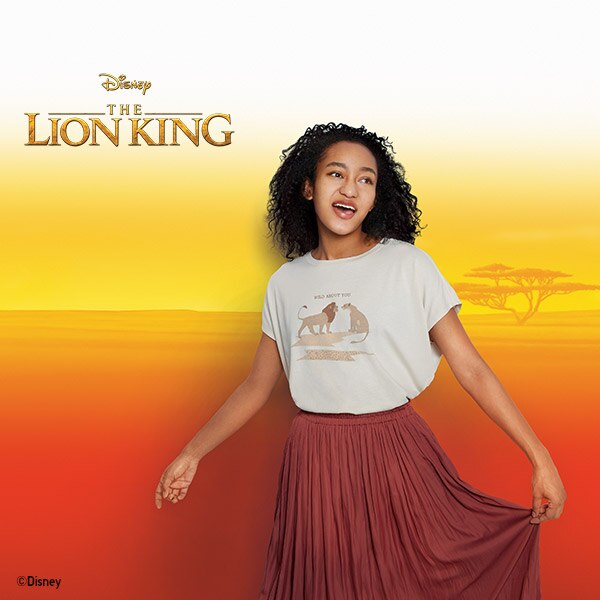Femme en T-shirt blanc de la collection Le Roi Lion avec comme imprimé Simba et Nala et le slogan « Wild About You »