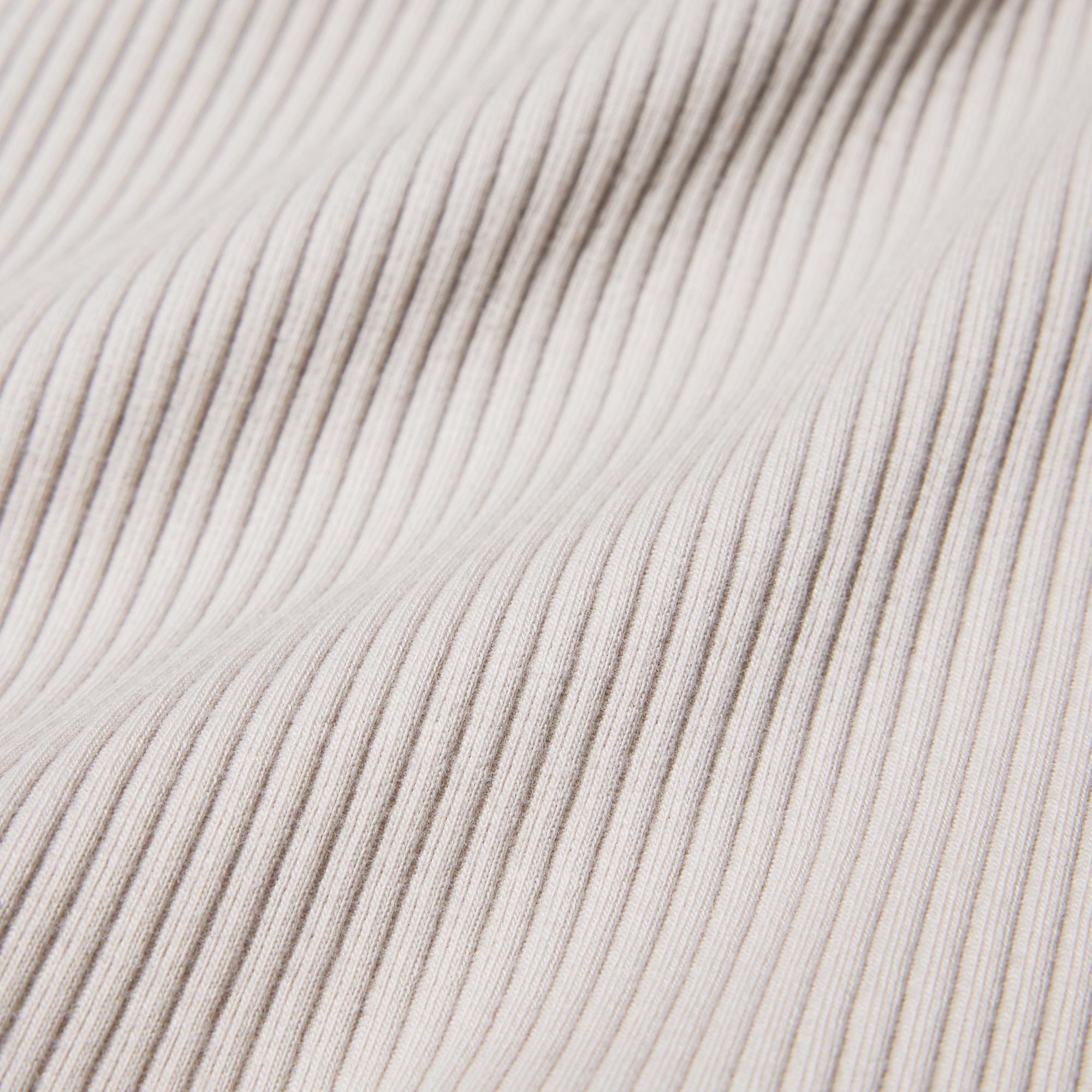 Ribbed fabric with moderate thickness and unevenness.