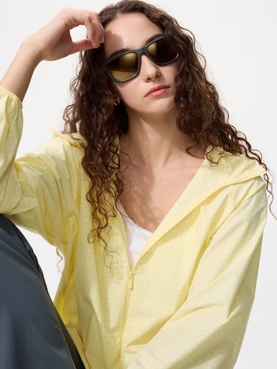 model wearing active Sunglasses with a pink zip-up hoodie, black top and shorts