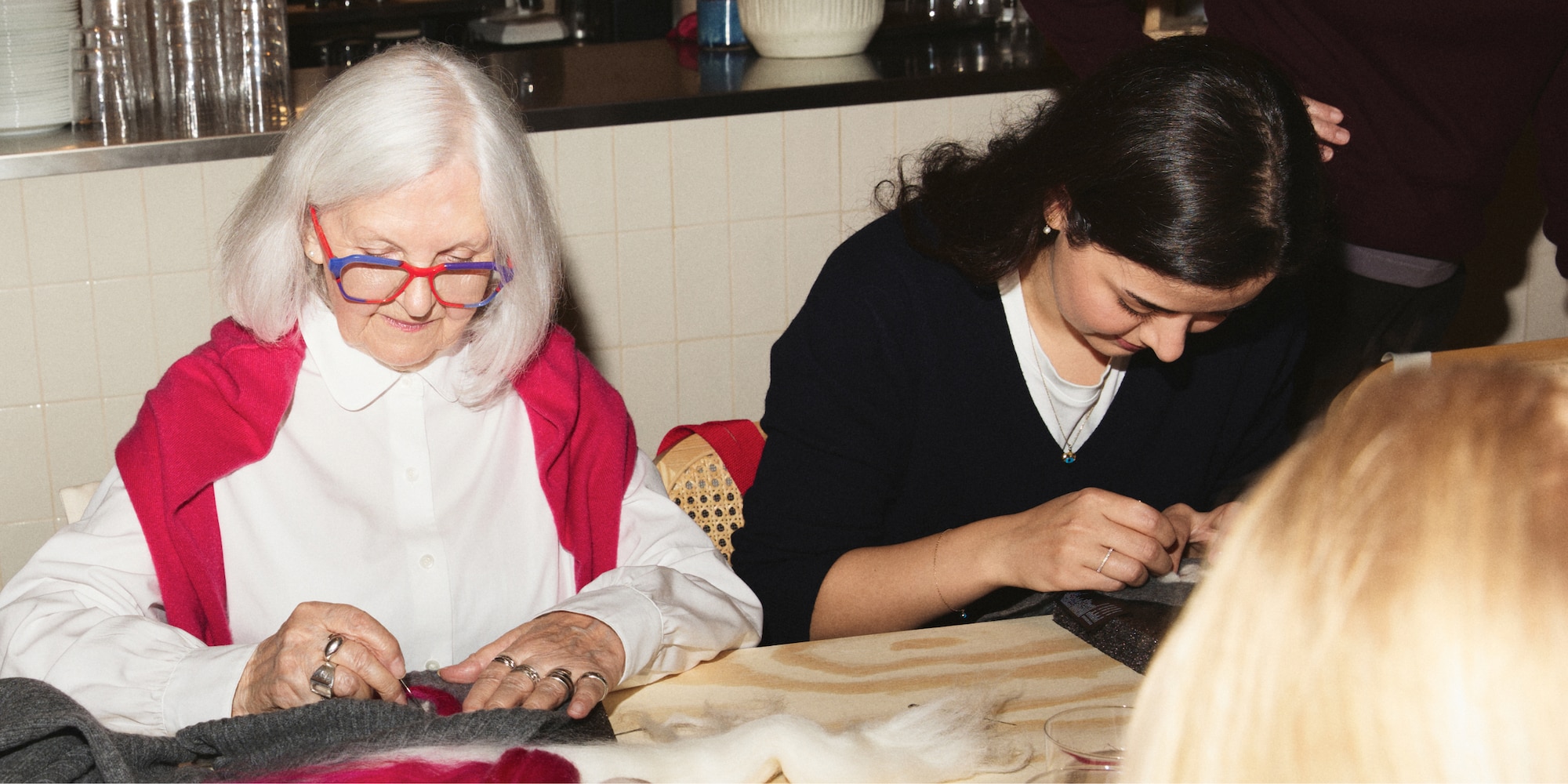Woman in white shirt and red cashmere jumper