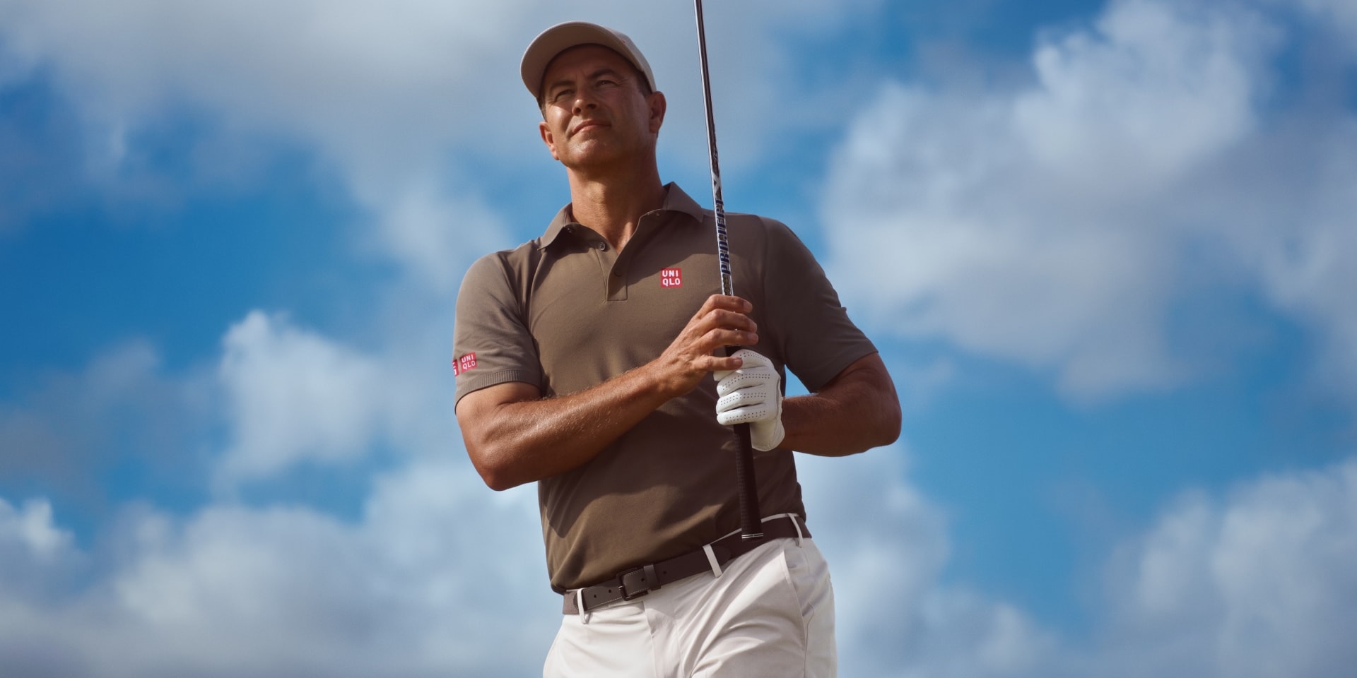 professional golfer and uniqlo global brand ambassador Adam Scott wearing a dark grey uniqlo polo shirt and cap with off white trousers
