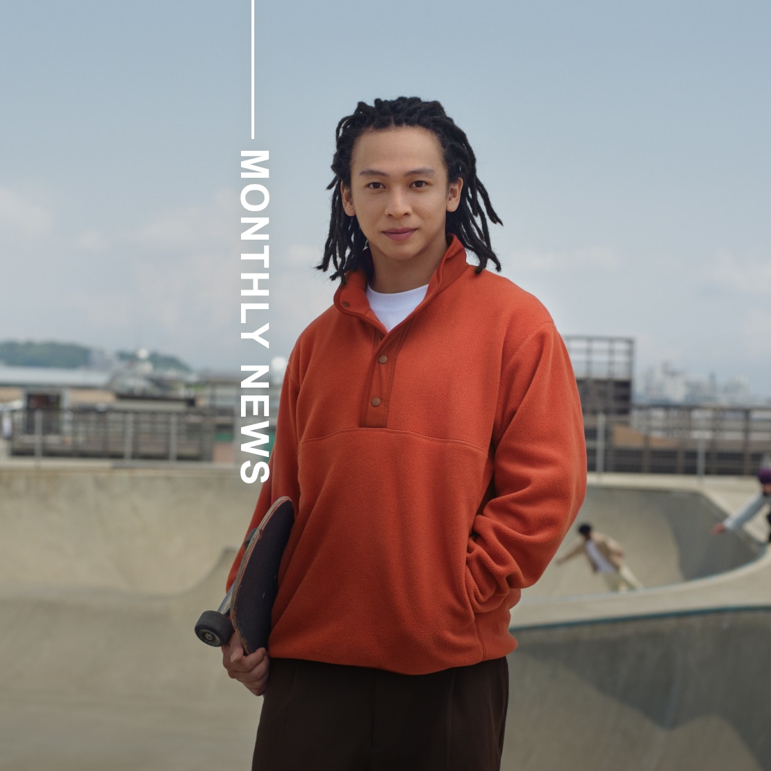 Professional Skateboarder & Snowboarder Ayumu Hirano wearing an orange button-up fleece pullover and holding a skateboard