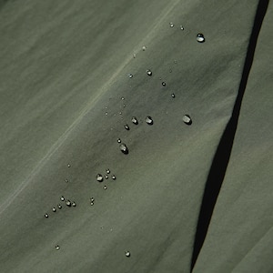 Bahan fungsional yang memiliki lapisan tahan angin dan water-repellent*.*Bahan dilapisi dengan lapisan water-repellent sehingga efeknya tahan lebih lama. Lapisan ini tidak permanen.
