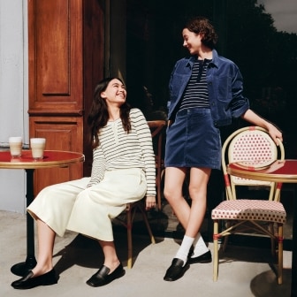 two models wearing UNIQLO and COMPTOIR DES COTONNIERS Autumn/Winter 2026 Collection​ while outside a Parisian café