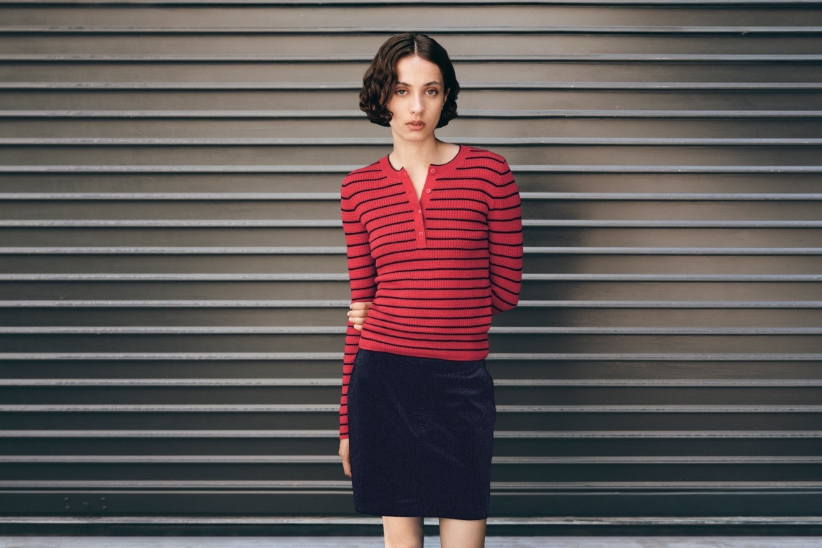 model wearing red and black striped henley with a black mini skirt