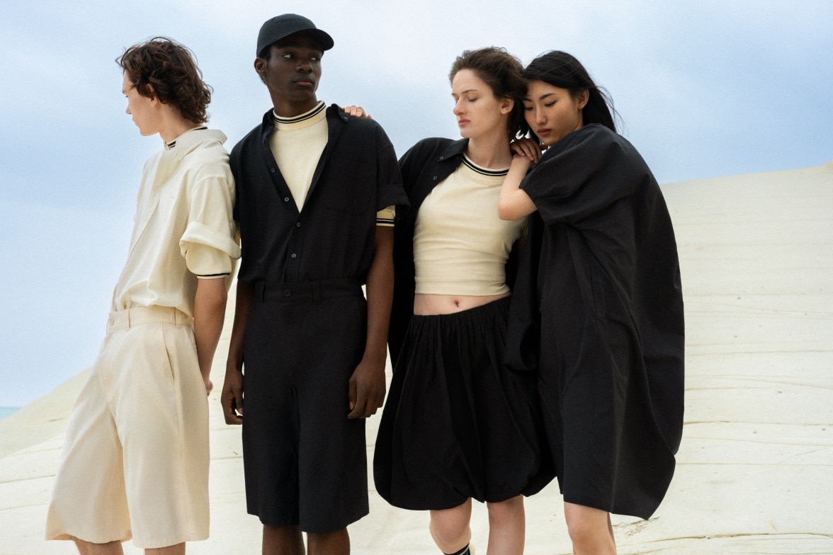 four models wearing shorts and skirts in shades of off white and black