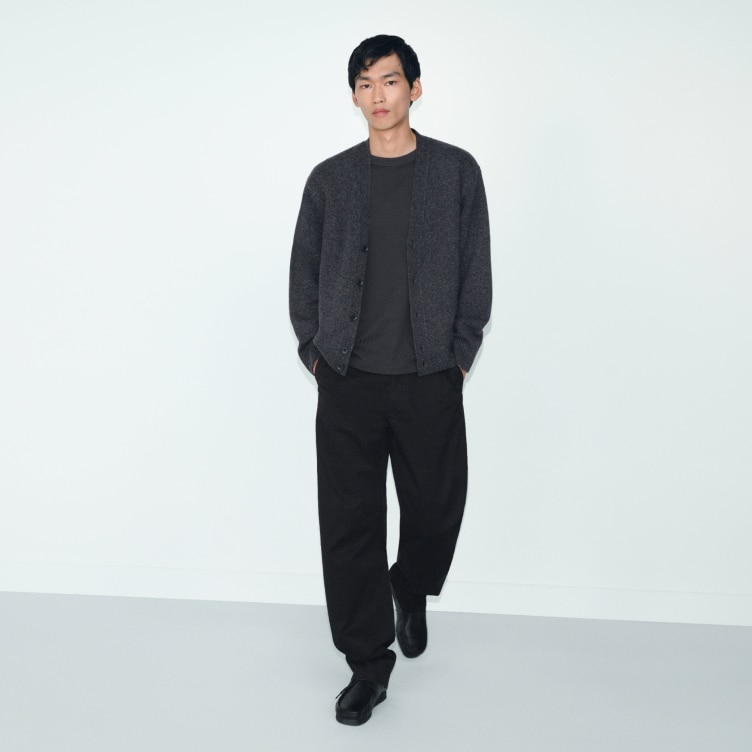 model wearing dark grey cardigan over a dark grey top with black trousers and shoes