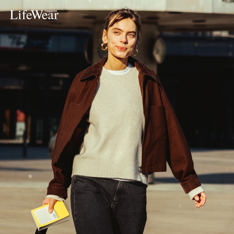 actor Greta Krämer wearing Zip-Up Short Jacket, Soufflé Yarn Crew Neck Jumper, Soft Ribbed T-Shirt, Denim Culottes and carrying Soft Coated Drawstring Bag while walking past the world clock in Berlin