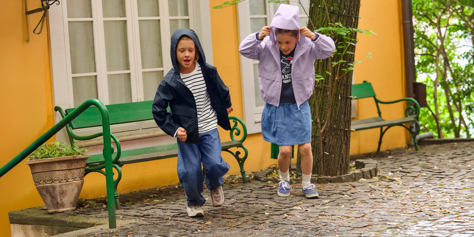 two models wearing BLOCKTECH Parkas in navy and light purple while running in the rain