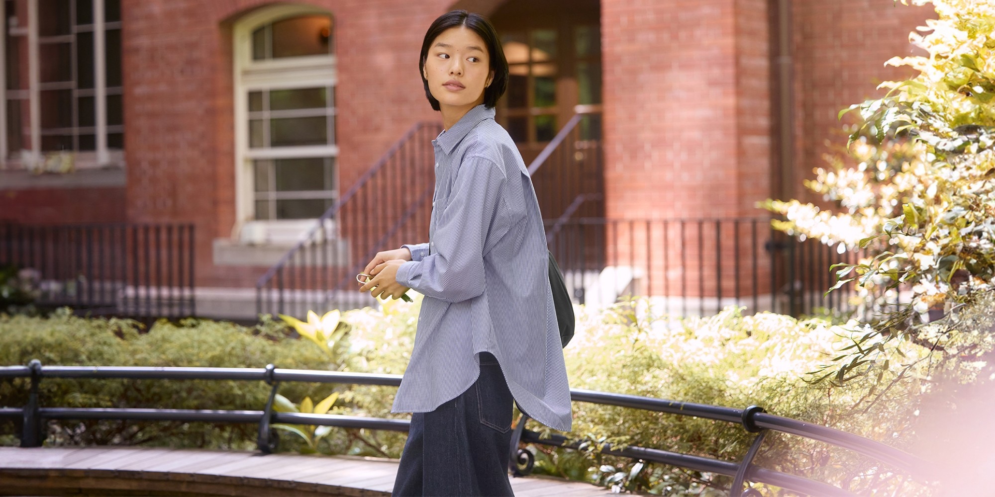 woman outside wearing an oversized long sleeve striped stand collar shirt