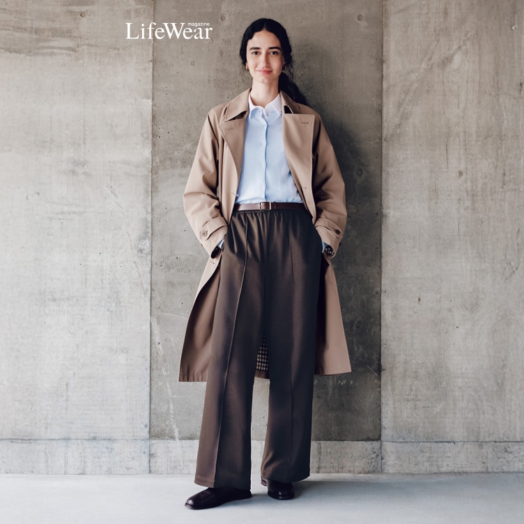 model draagt een beige trenchcoat en een bruine Wijde Easy Broek