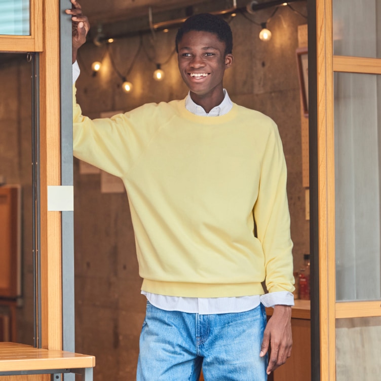model wearing Washable Cotton Crew Neck Jumper in yellow over a shirt with mid wash jeans