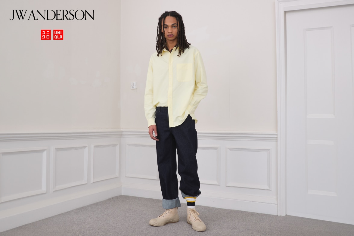 model wearing Straight Jeans in dark wash with a light yellow shirt, yellow and navy striped socks and beige trainers