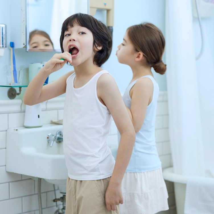 two models in a bathroom brushing their teeth while wearing AIRism vest tops