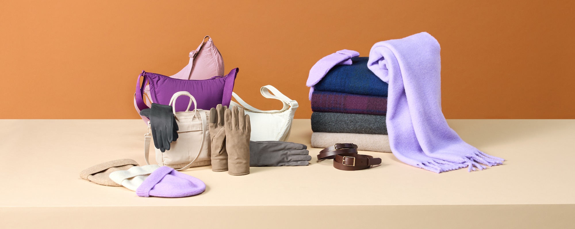 an arrangement of hats, bags, gloves, mittens, scarves and belts in a range of colours