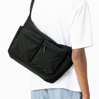 model wearing a white T-shirt and a Multi Pocket Shoulder Bag in black