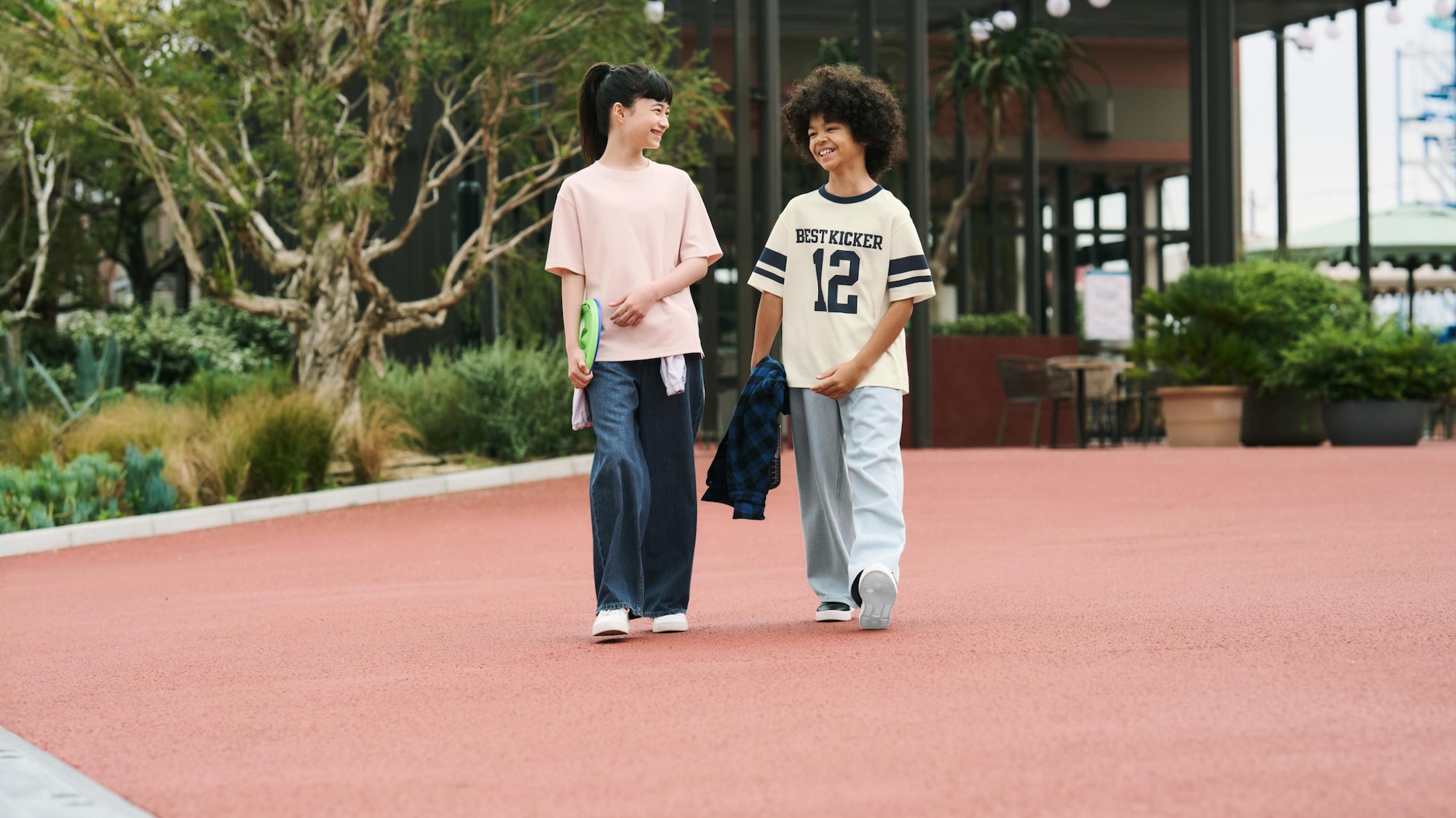 een meisje en een jongen dragen UNIQLO jeans en T-shirts