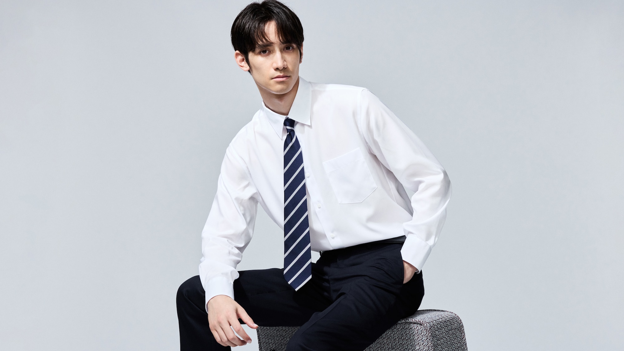 model wearing Super Non-Iron Slim Fit Shirt in white with grey trousers and a black belt