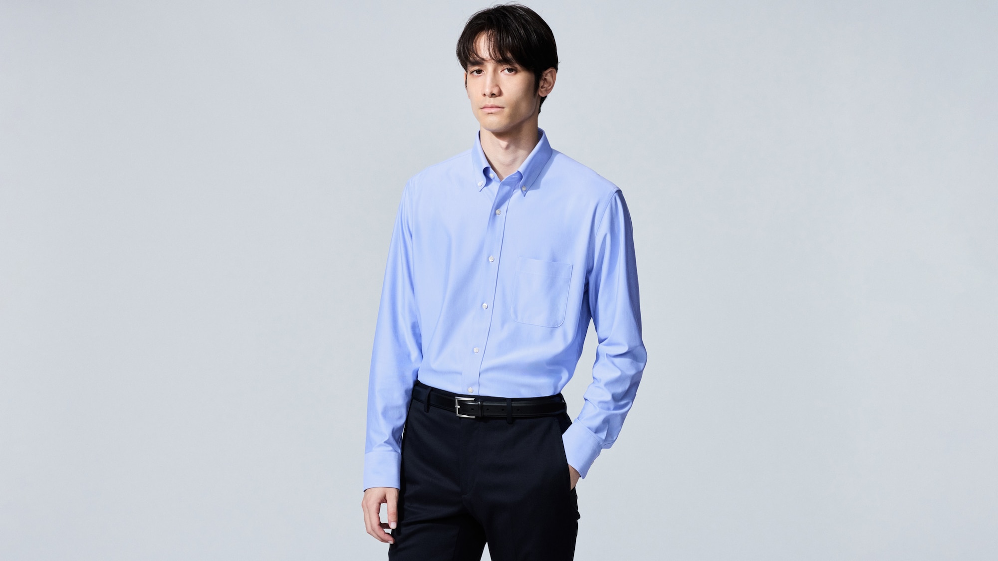 model wearing Super Non-Iron Slim Fit Shirt in blue with black trousers and a black belt