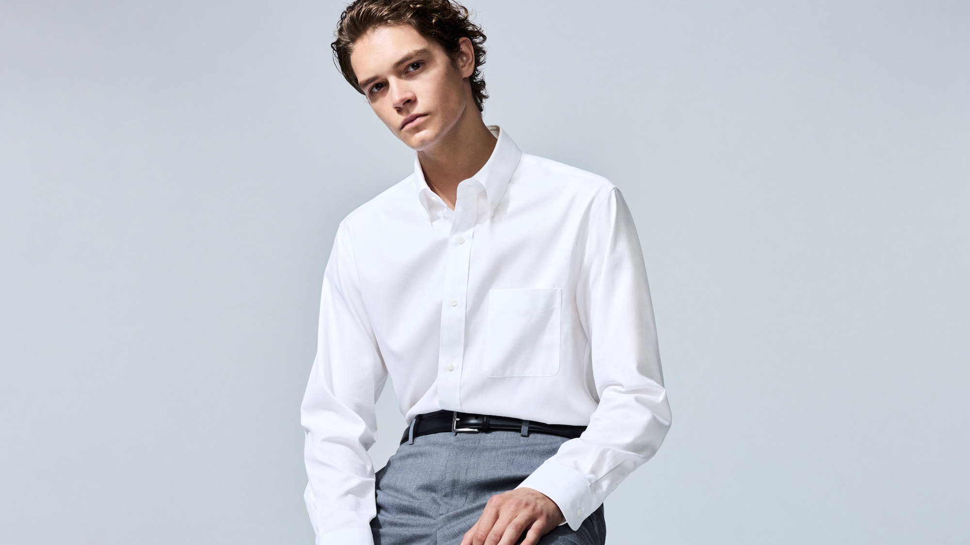 model wearing Super Non-Iron Slim Fit Shirt in white with grey trousers and a black belt