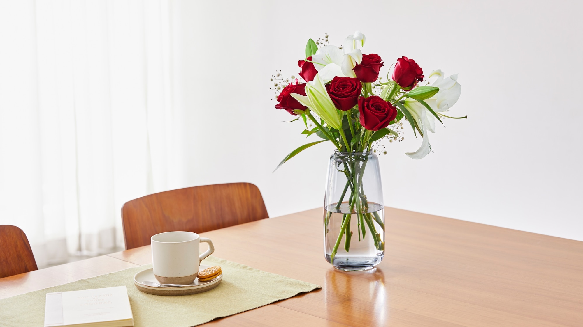 花瓶に飾られた赤いバラの画像