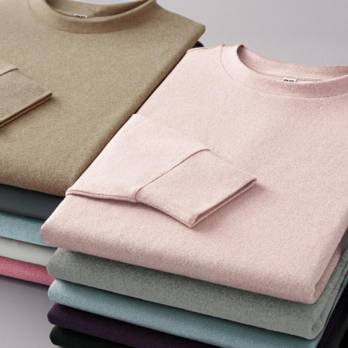 two piles of folded Soft Knit Fleece Crew Neck T-Shirts in different colours