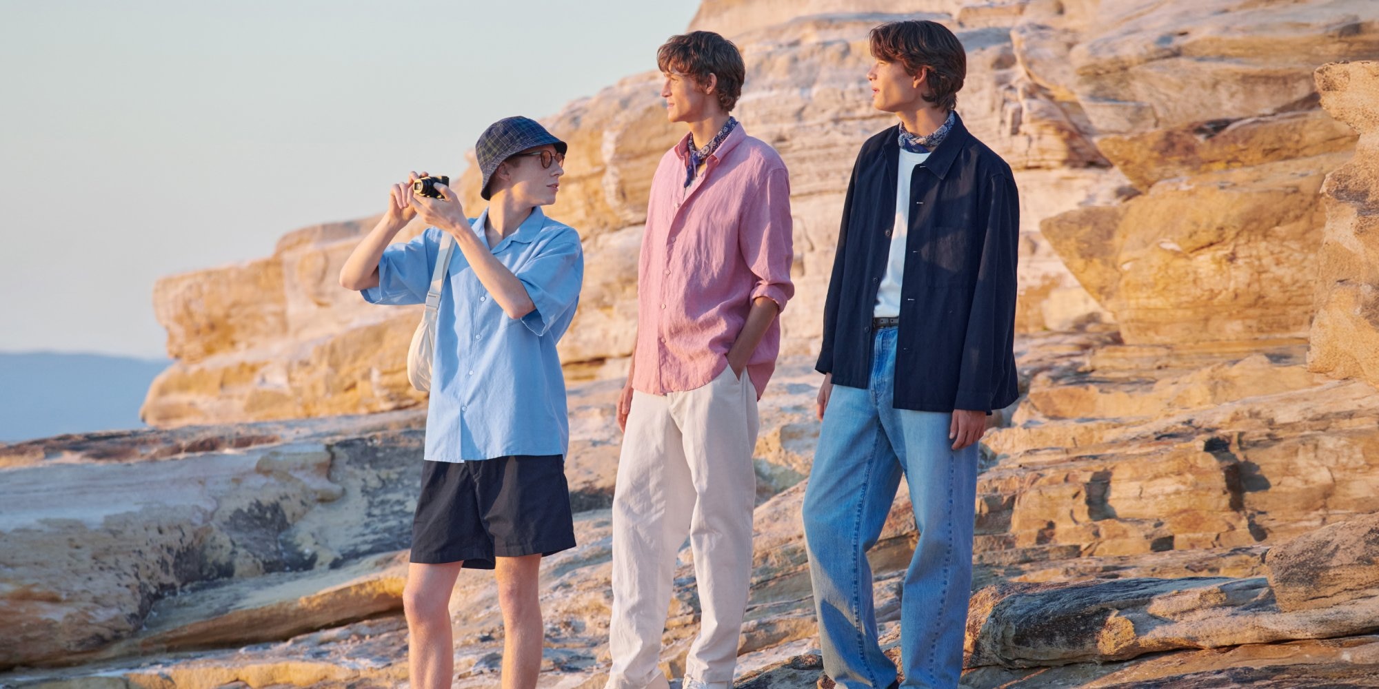 three models wearing UNIQLO linen while standing on the coastline