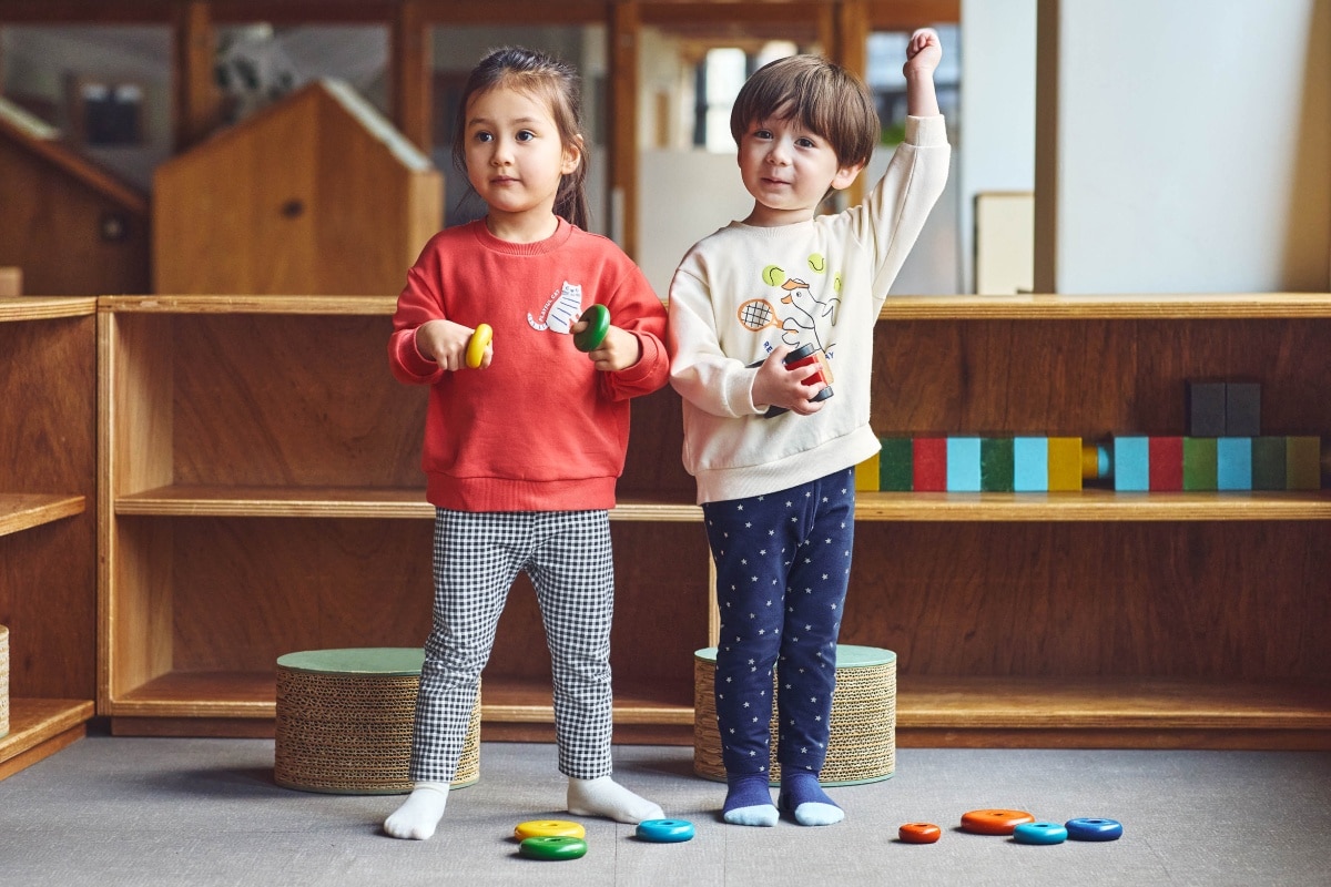 two models wearing uniqlo leggings while playing with wooden toys