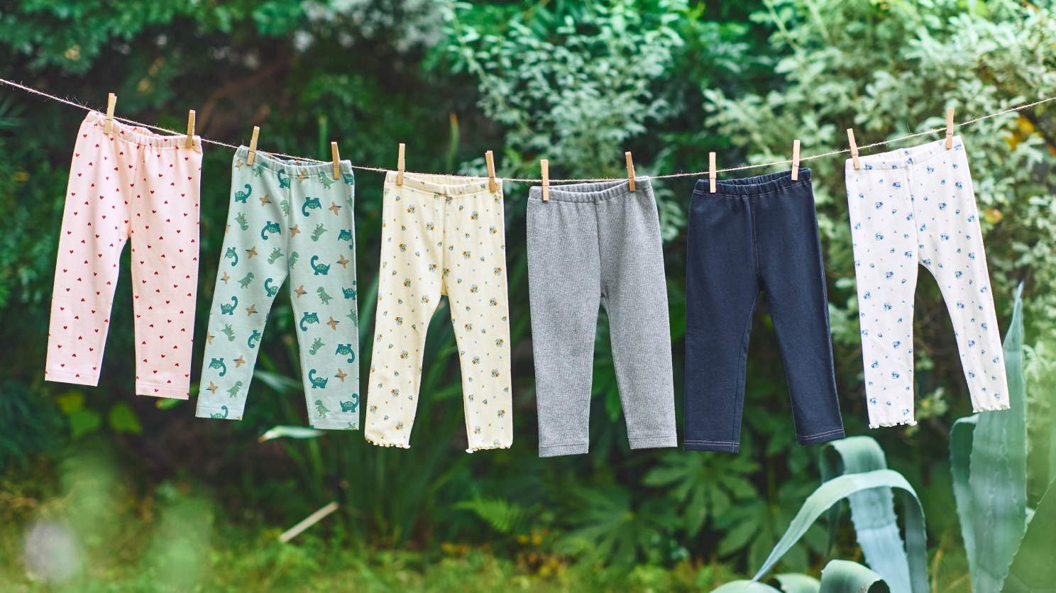 various leggings in printed and plain designs hanging from an outdoor washing line