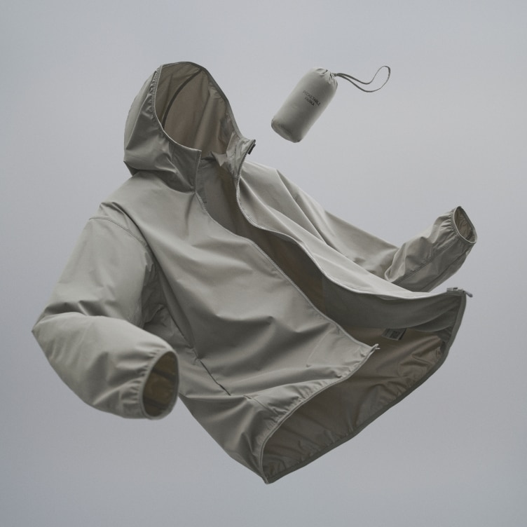 pocketable parka in light grey floating against a mid grey background