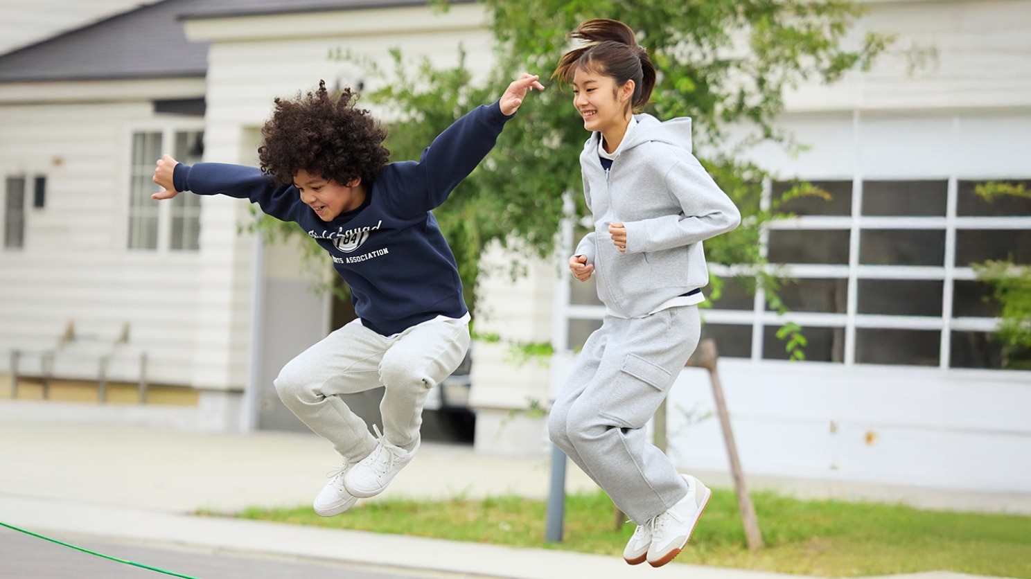 two models wearing UNIQLO sweats while jumping