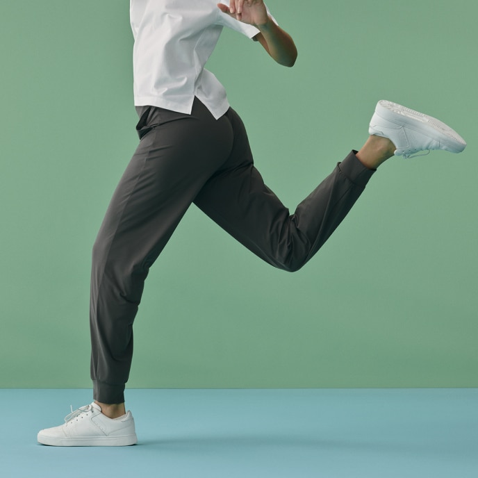 model wearing Ultra Stretch Joggers in grey with white trainers while running