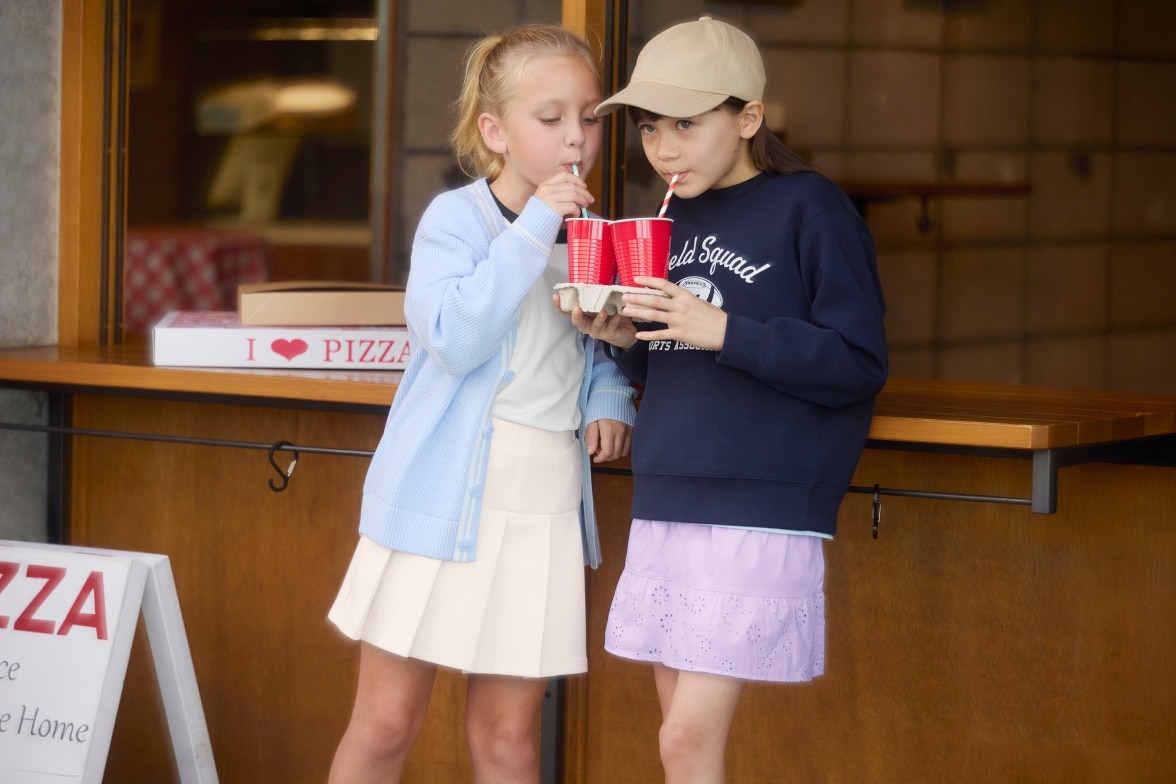 two models wearing UNIQLO skorts while drinking through straws from red cups