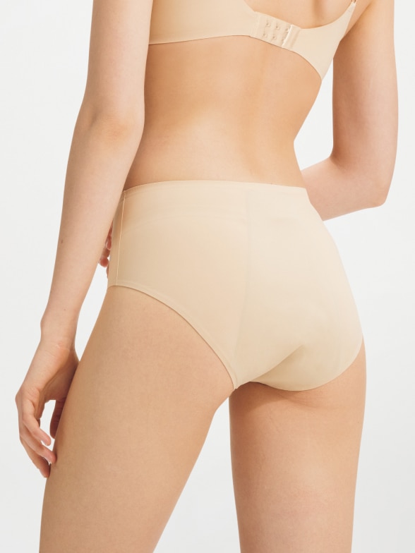 model wearing AIRism Period Pants in beige with a matching bra