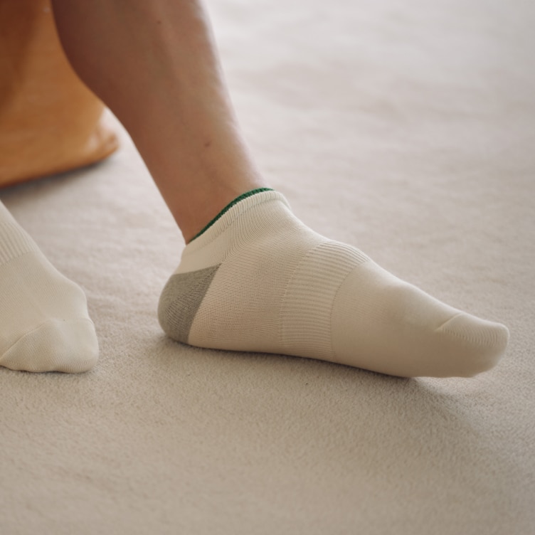 model wearing Short Socks in off white while sat on the floor