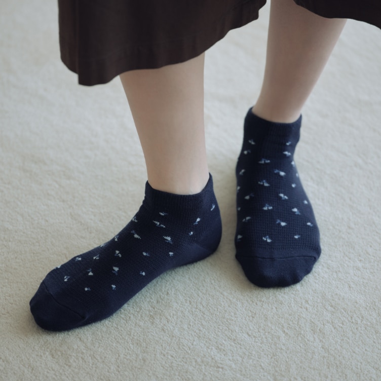 model wearing Short Socks in navy with a floral design with dark brown culottes