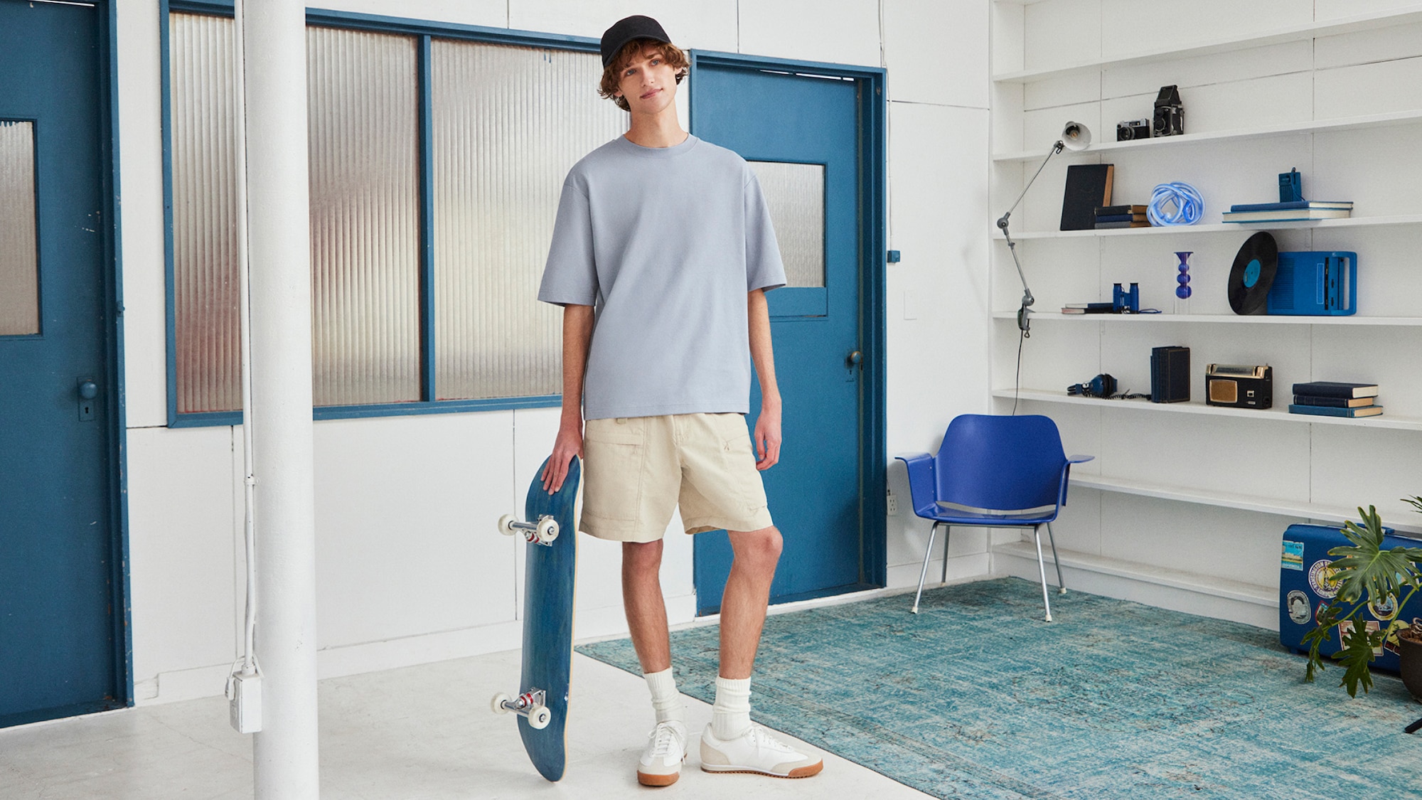Homme avec un skateboard prenant la pose vêtu d'un t-shirt AIRism UNIQLO