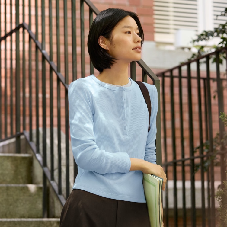 model wearing Ribbed Henley Neck Long Sleeve T-Shirt in blue with brown trousers