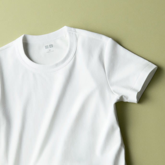 Crew Neck T-Shirt in white lying on a beige background