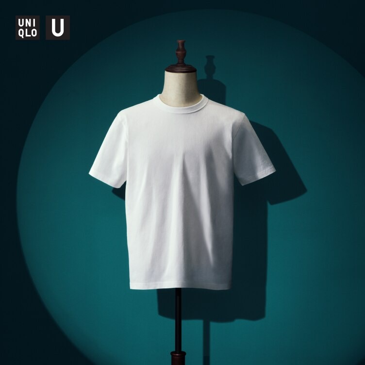 white crew neck T-shirt on a mannequin against a dark teal wall