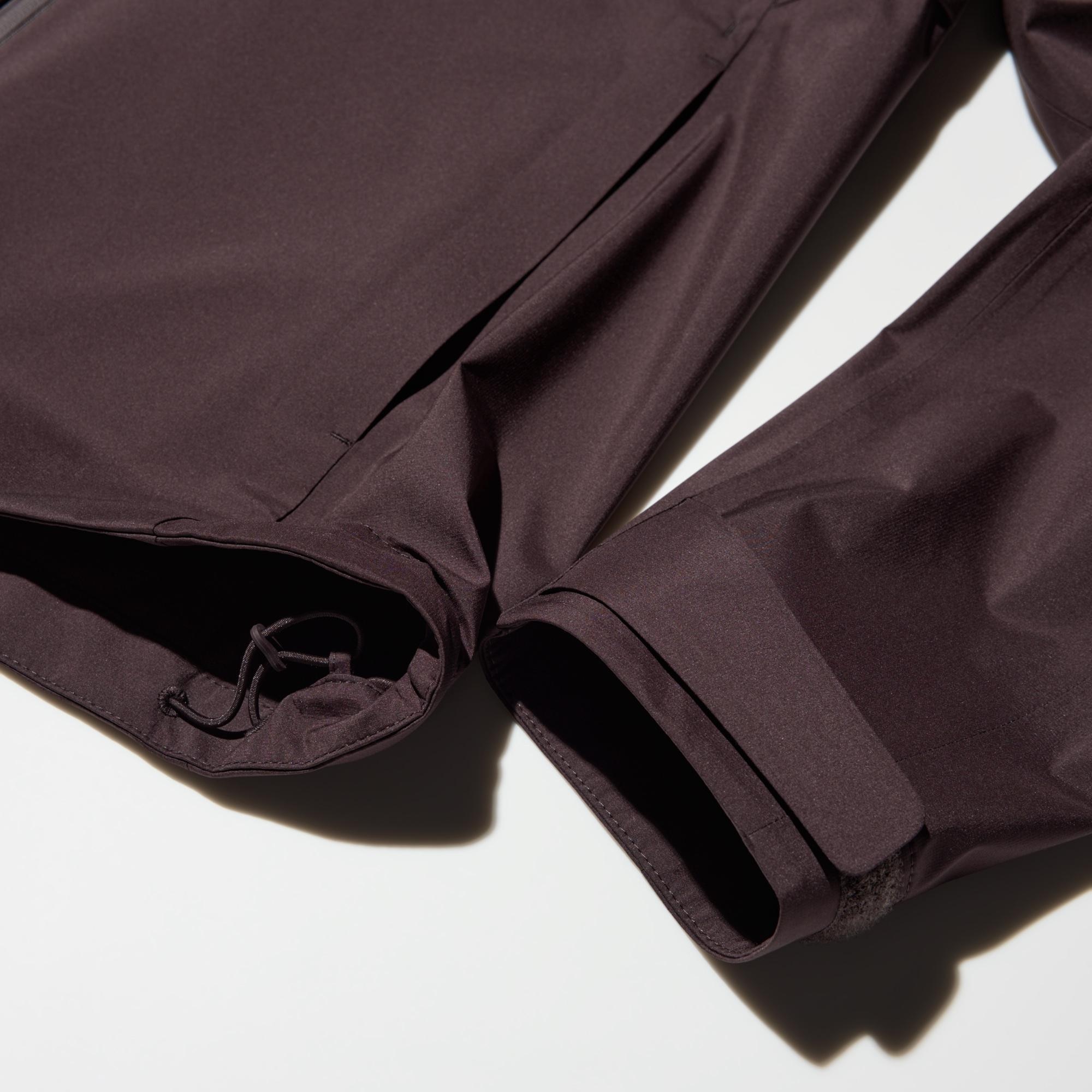 Asymmetric hem with tape at the cuffs to adjust the fit.