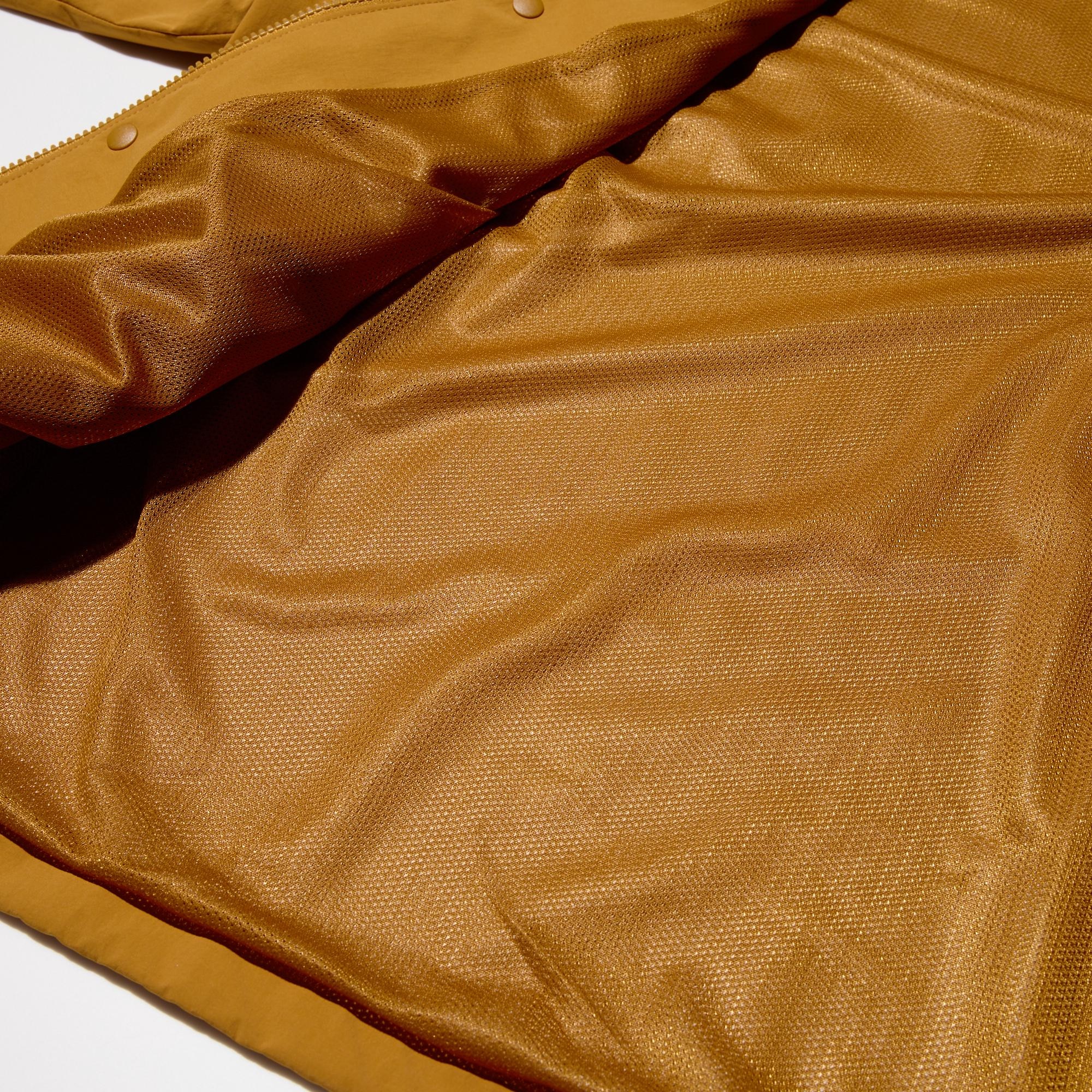 Functional fabric with a windproof laminated film and a mesh lining for comfort. High-performance outerwear for changeable weather conditions.