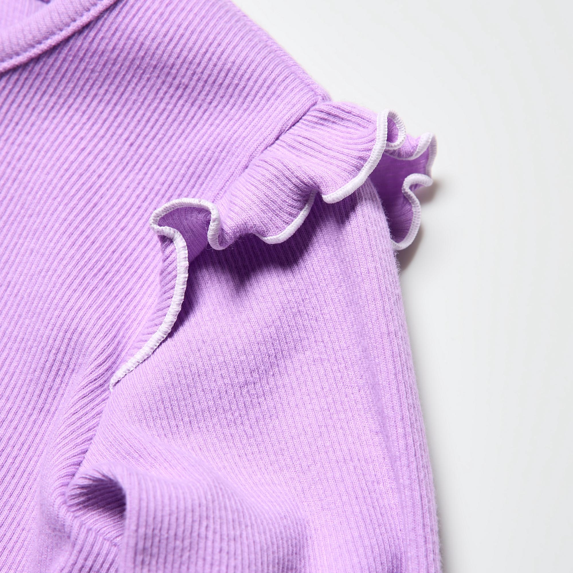 Features frills at the shoulders. Styles alone or layered.