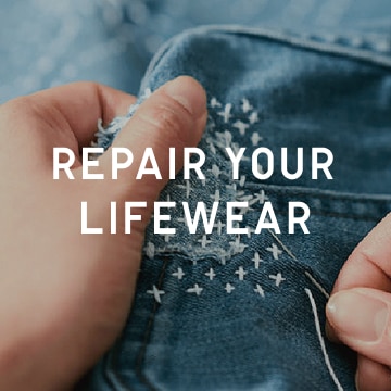 repair your lifewear. closeup of hands stitching a unique pattern on jeans
