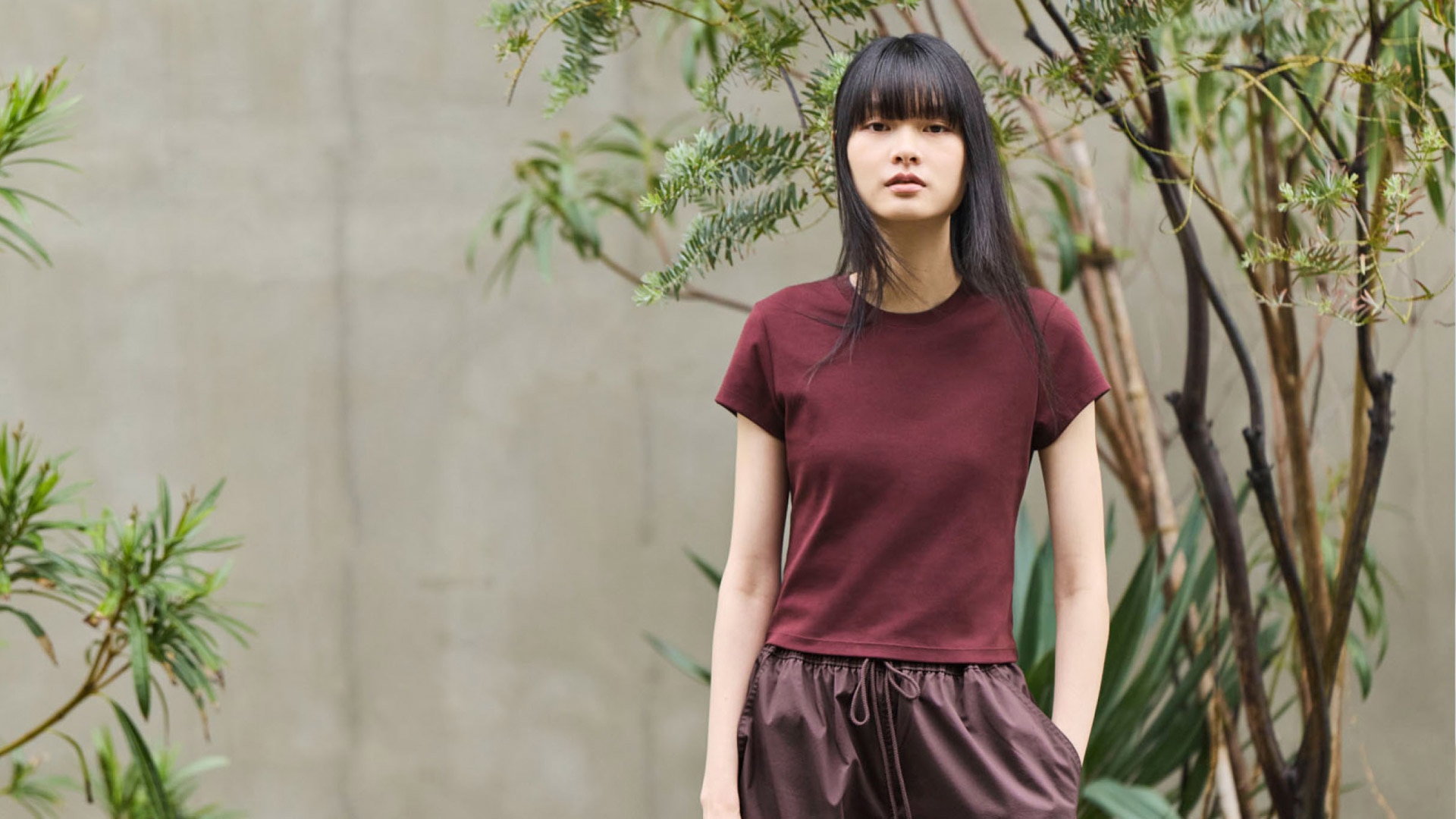 Woman outside wearing a maroon short sleeve shirt