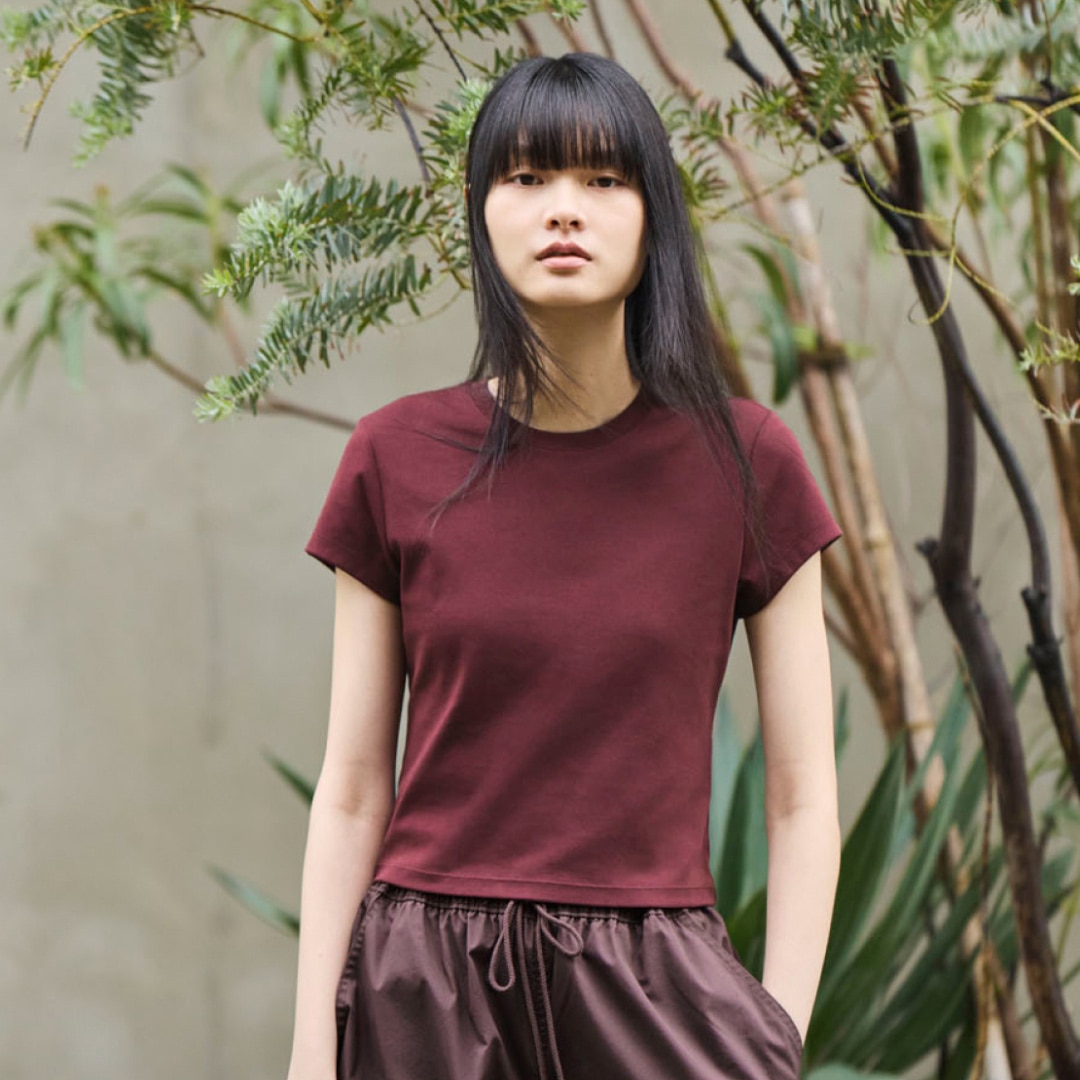 Woman outside wearing a maroon short sleeve shirt