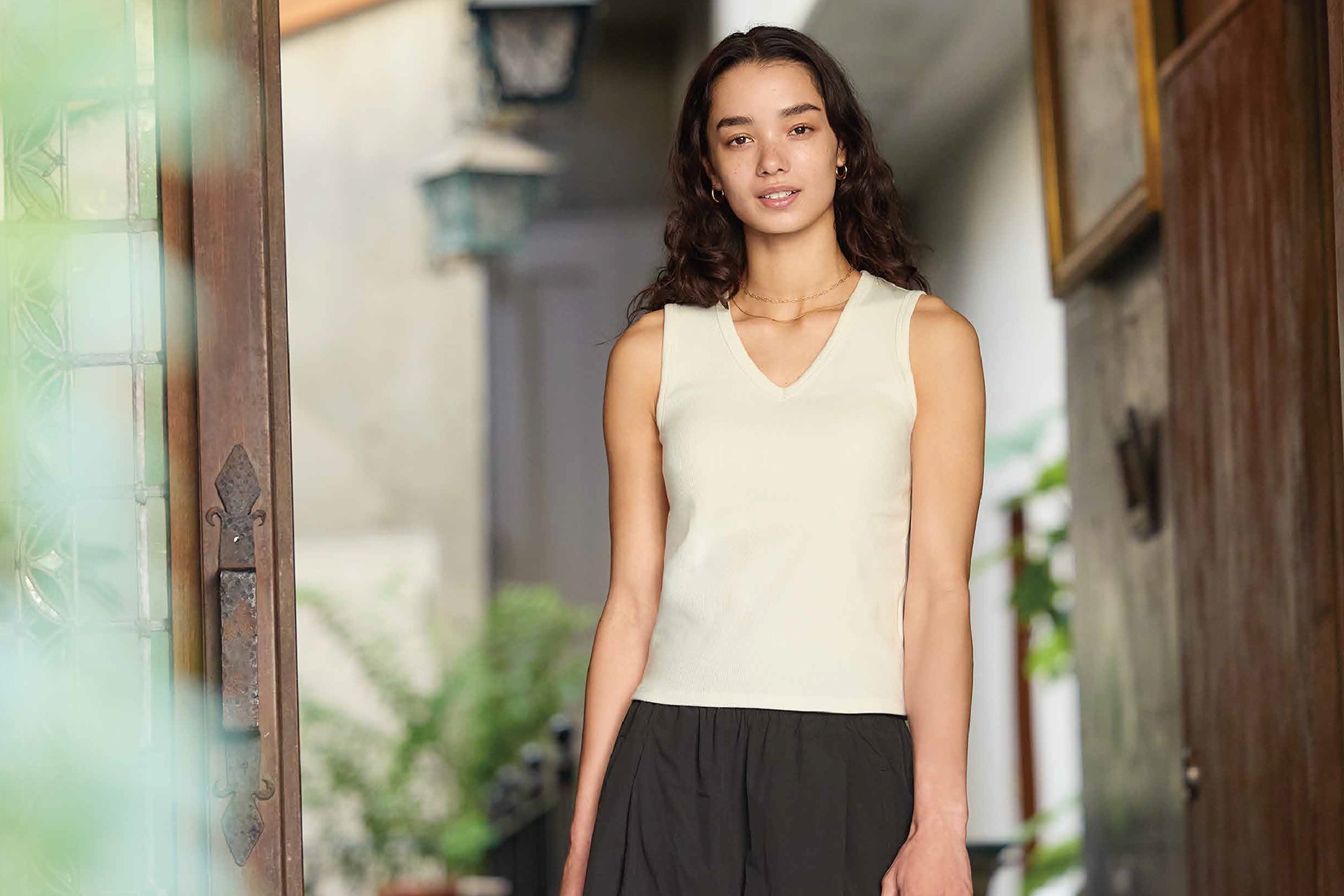 Woman wearing a white V-neck bra top and brown pants