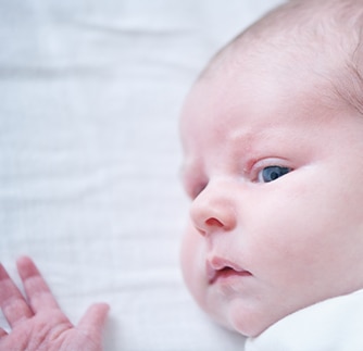 Cute baby looking over his shoulder at the photographer